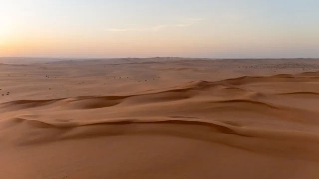 منظر جوي للكثبان الرملية الذهبية في الصحراء عند غروب الشمس