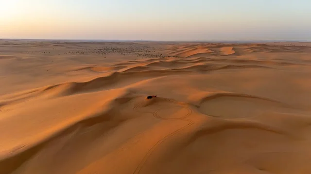 لقطة جوية للكثبان الرملية الصحراوية الواسعة عند الغروب
