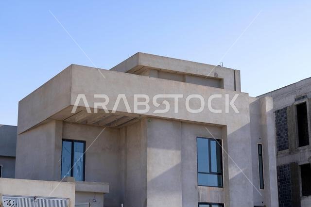 New house under construction in Riyadh, Saudi Arabia, showing cement walls, unfinished structure, and early building stages of a residential property.
