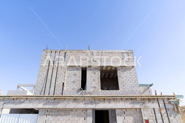 New house under construction in Riyadh, Saudi Arabia, showing cement walls, unfinished structure, and early building stages of a residential property.