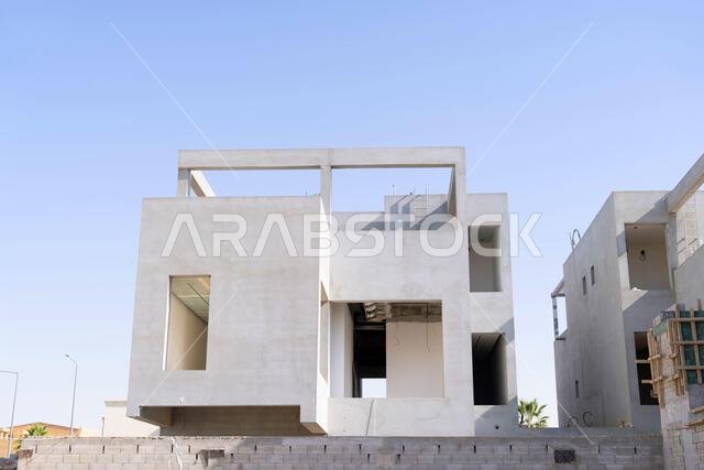 New house under construction in Riyadh, Saudi Arabia, showing cement walls, unfinished structure, and early building stages of a residential property.
