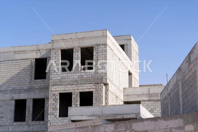 New house under construction in Riyadh, Saudi Arabia, showing cement walls, unfinished structure, and early building stages of a residential property.