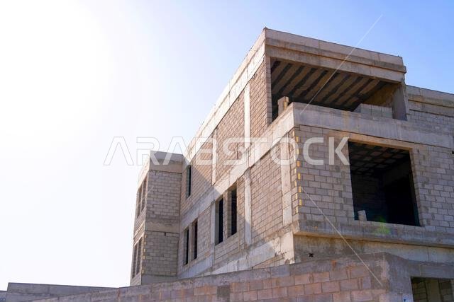 New house under construction in Riyadh, Saudi Arabia, showing cement walls, unfinished structure, and early building stages of a residential property.