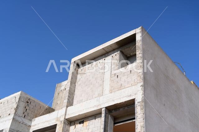 New house under construction in Riyadh, Saudi Arabia, showing cement walls, unfinished structure, and early building stages of a residential property.