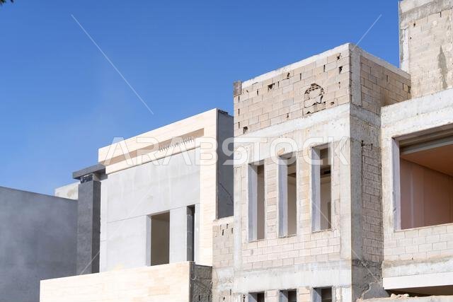 New house under construction in Riyadh, Saudi Arabia, showing cement walls, unfinished structure, and early building stages of a residential property.