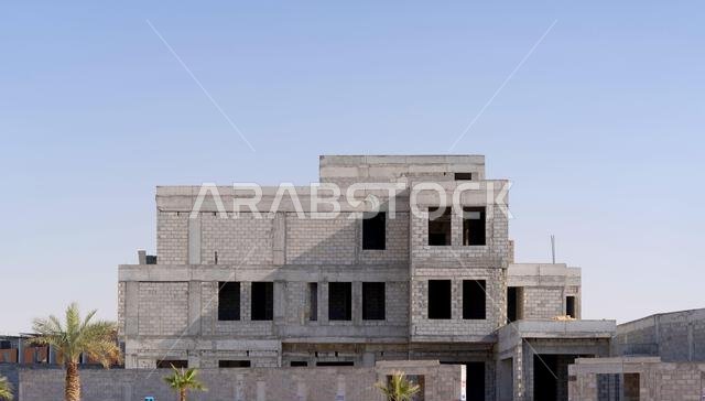 New house under construction in Riyadh, Saudi Arabia, showing cement walls, unfinished structure, and early building stages of a residential property.