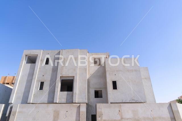 New house under construction in Riyadh, Saudi Arabia, showing cement walls, unfinished structure, and early building stages of a residential property.