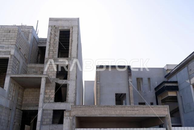 New house under construction in Riyadh, Saudi Arabia, showing cement walls, unfinished structure, and early building stages of a residential property.