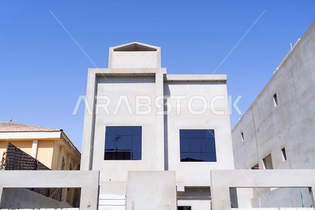 New house under construction in Riyadh, Saudi Arabia, showing cement walls, unfinished structure, and early building stages of a residential property.
