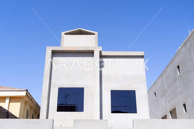 New house under construction in Riyadh, Saudi Arabia, showing cement walls, unfinished structure, and early building stages of a residential property.