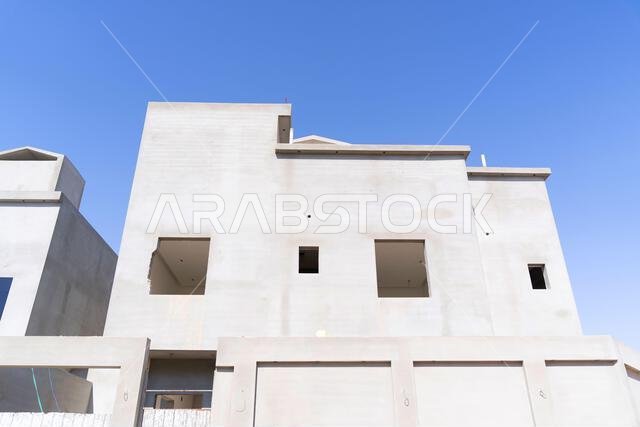 New house under construction in Riyadh, Saudi Arabia, showing cement walls, unfinished structure, and early building stages of a residential property.