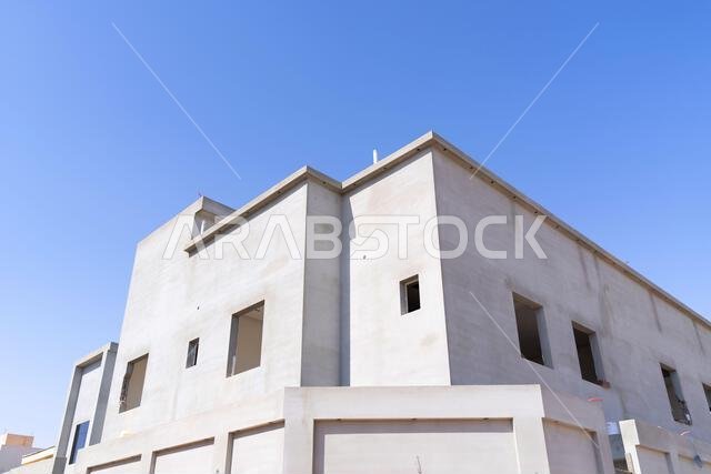 New house under construction in Riyadh, Saudi Arabia, showing cement walls, unfinished structure, and early building stages of a residential property.