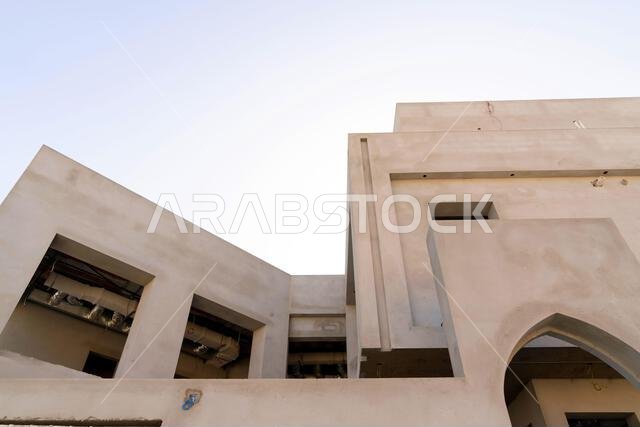 New house under construction in Riyadh, Saudi Arabia, showing cement walls, unfinished structure, and early building stages of a residential property.