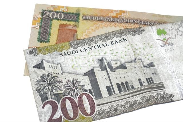 يُظهر الوجه الخلفي للورقة النقدية القديمة والجديدة من فئة 200 ريال سعودي قصر المصمك وقصر الحكم في ري