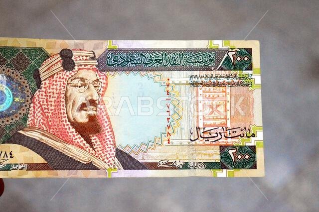 The obverse side of 200 SAR two hundred Saudi Arabia riyal cash money banknote bill, features King Abdulaziz Al Saud, picture of the door of Al-Masmak