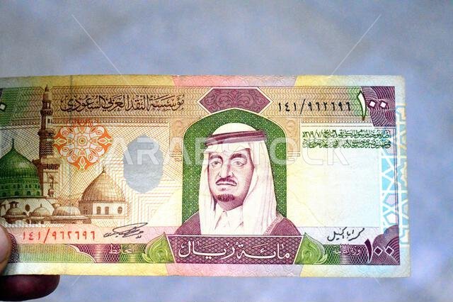 the obverse side of 100 SAR one hundred Saudi Arabian riyals cash money banknote bill, features a portrait of king Fahd Bin AbdulAziz and the Prophet' the obverse side of 100 SAR one hundred Saudi Arabian riyals cash money banknote bill, features a portrait of king Fahd Bin AbdulAziz and the Prophet'