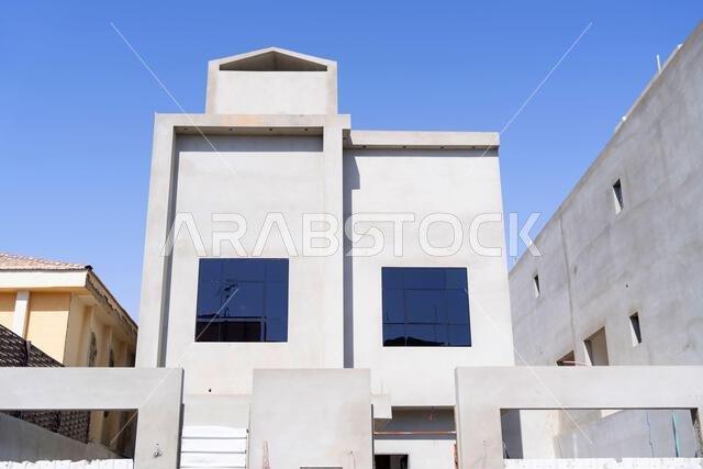 منزل جديد قيد الإنشاء في الرياض، المملكة العربية السعودية، يظهر جدراناً إسمنتية، وهيكلاً غير مكتمل، ومراحل بناء مبكرة لعقار سكني. منزل جديد قيد الإنشاء في الرياض، المملكة العربية السعودية، يظهر جدراناً إسمنتية، وهيكلاً غير مكتمل، ومراحل بناء مبكرة لعقار سكني.