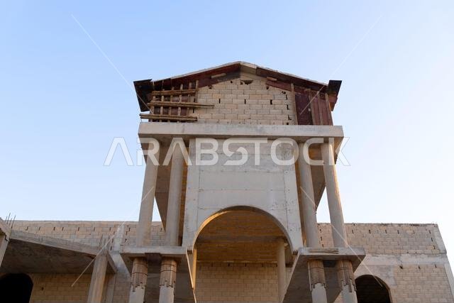 New house under construction in Riyadh, Saudi Arabia, showing cement walls, unfinished structure, and early building stages of a residential property.