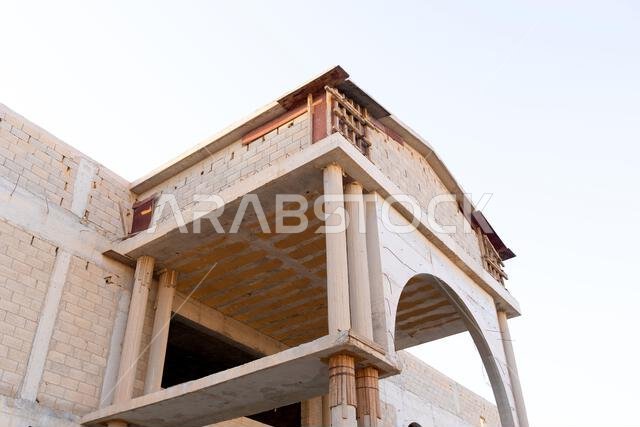New house under construction in Riyadh, Saudi Arabia, showing cement walls, unfinished structure, and early building stages of a residential property.