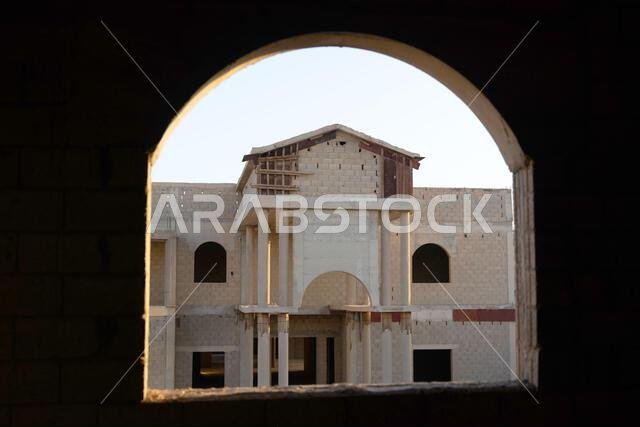 New house under construction in Riyadh, Saudi Arabia, showing cement walls, unfinished structure, and early building stages of a residential property.