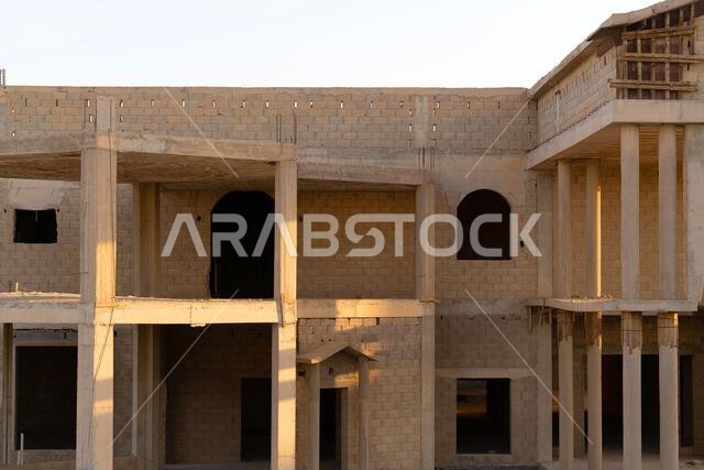 New house under construction in Riyadh, Saudi Arabia, showing cement walls, unfinished structure, and early building stages of a residential property.