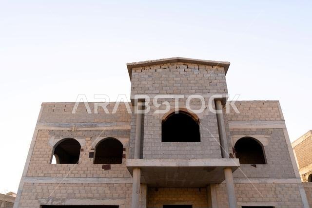 New house under construction in Riyadh, Saudi Arabia, showing cement walls, unfinished structure, and early building stages of a residential property.