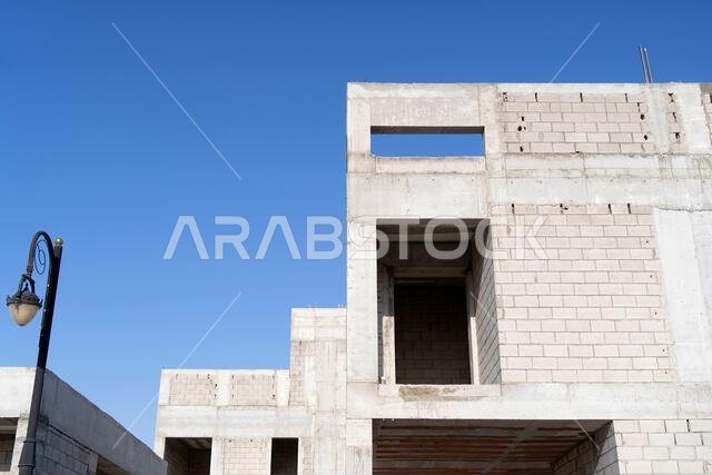 New house under construction in Riyadh, Saudi Arabia, showing cement walls, unfinished structure, and early building stages of a residential property.