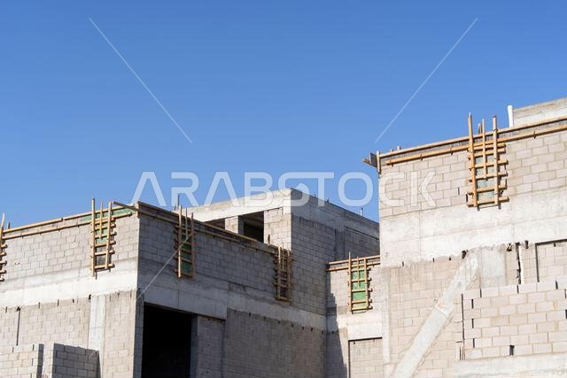 New house under construction in Riyadh, Saudi Arabia, showing cement walls, unfinished structure, and early building stages of a residential property.