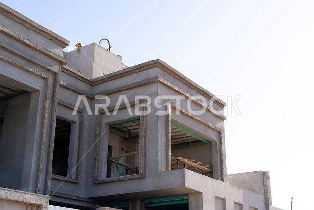 New house under construction in Riyadh, Saudi Arabia, showing cement walls, unfinished structure, and early building stages of a residential property.
