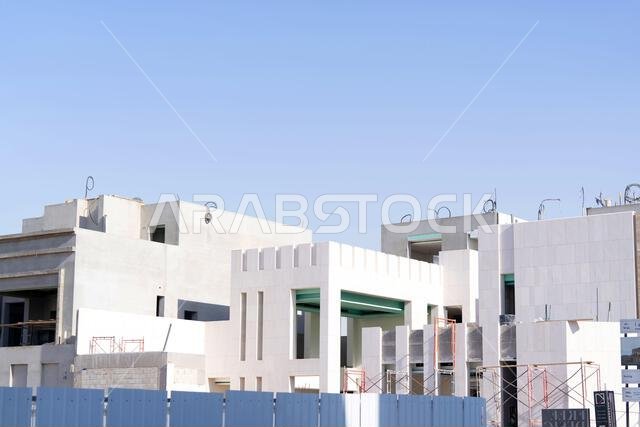 New house under construction in Riyadh, Saudi Arabia, showing cement walls, unfinished structure, and early building stages of a residential property.