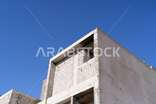 New house under construction in Riyadh, Saudi Arabia, showing cement walls, unfinished structure, and early building stages of a residential property.