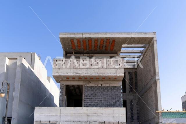 New house under construction in Riyadh, Saudi Arabia, showing cement walls, unfinished structure, and early building stages of a residential property.