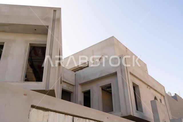 New house under construction in Riyadh, Saudi Arabia, showing cement walls, unfinished structure, and early building stages of a residential property.