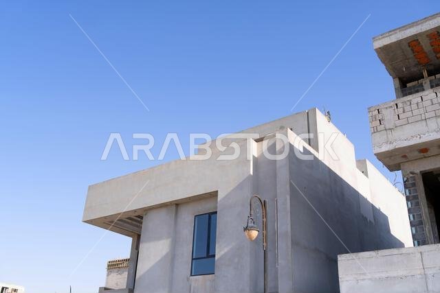 New house under construction in Riyadh, Saudi Arabia, showing cement walls, unfinished structure, and early building stages of a residential property.