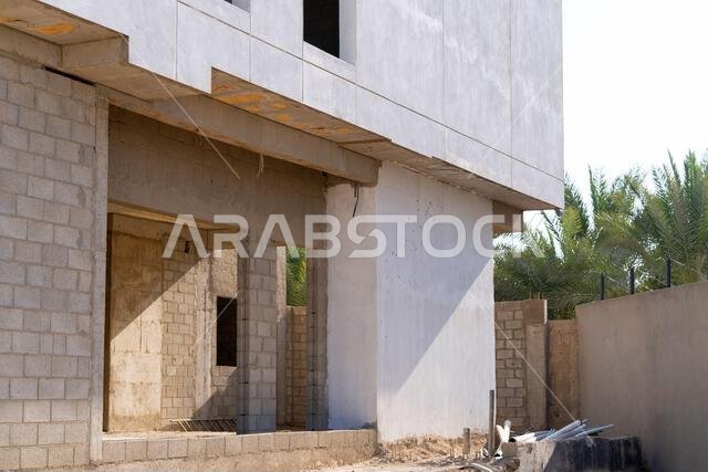 New house under construction in Riyadh, Saudi Arabia, showing cement walls, unfinished structure, and early building stages of a residential property.