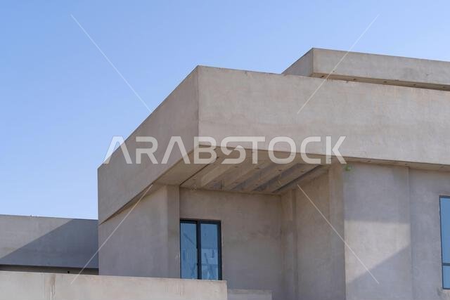 New house under construction in Riyadh, Saudi Arabia, showing cement walls, unfinished structure, and early building stages of a residential property.