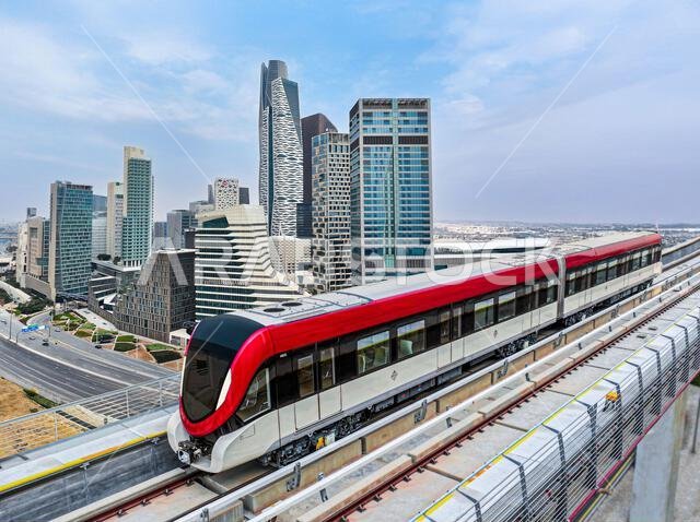 Riyadh Metro Red Line train running on its route with King Abdullah Financial District skyline in the background, Riyadh, Saudi Arabia.
