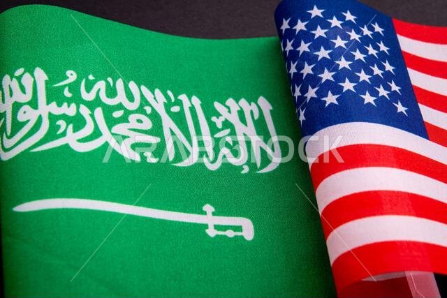 The national flag of Saudi Arabia together with the USA national flag isolated on black. A Saudi Arabia, USA relations concept.