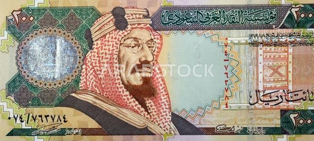 جزء كبير من وجه ورقة نقدية من فئة 200 ريال سعودي، يظهر عليه صورة الملك عبد العزيز آل سعود.