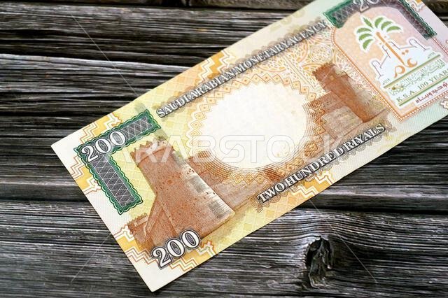 يظهر على الوجه الخلفي للورقة النقدية من فئة 200 ريال سعودي قصر المصمك في المنتصف، وشعار المملكة بمناسبة مرور مئة عام على تأسيسها، وحرف C.