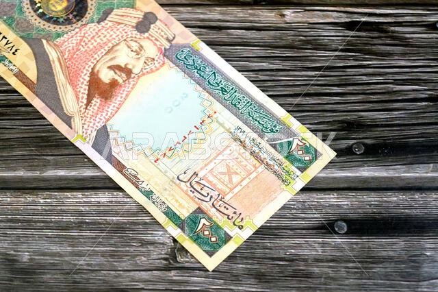 The obverse side of 200 SAR two hundred Saudi Arabia riyal cash money banknote bill, features King Abdulaziz Al Saud, picture of the door of Al-Masmak The obverse side of 200 SAR two hundred Saudi Arabia riyal cash money banknote bill, features King Abdulaziz Al Saud, picture of the door of Al-Masmak