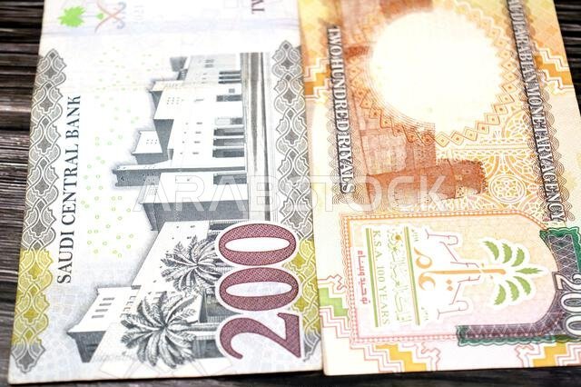 The reverse sides of old and new 200 SAR two hundred Saudi Arabia riyal cash money banknote bill, features Al Masmak Palace and the Qasr Al Hukm in Ri