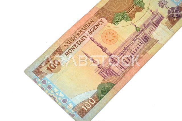 the reverse side of 100 SAR one hundred Saudi Arabian riyals cash money banknote bill, features a general view of the Holy Prophet's Mosque at Madina,