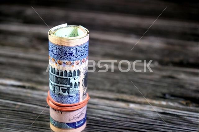 500 SAR five hundred Saudi riyals cash money banknote bills roll wrapped up with elastic rubber, features The Kaaba, inside the Great Mosque of Mecca,