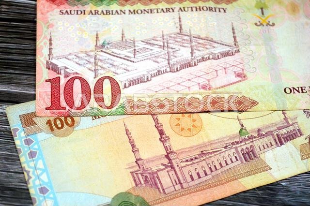 reverse sides of old and new 100 SAR one hundred Saudi Arabian riyals cash money banknote bill, features a general view of the Holy Prophet's Mosque a