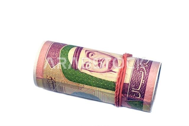 100 ريال سعودي، لفة من الأوراق النقدية ملفوفة بشريط مطاطي، تحمل صورة الملك فهد بن عبد العزيز.