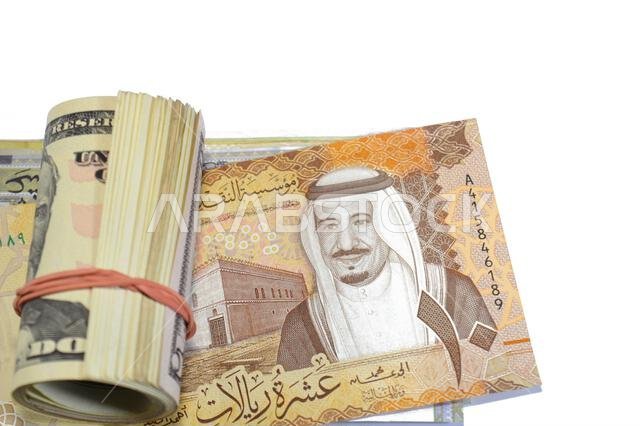 Saudi Arabian money SAR riyals bills and 50 USD fifty American dollars banknotes cash money rolled up with a rubber band, features Ulysses S. Grant, A