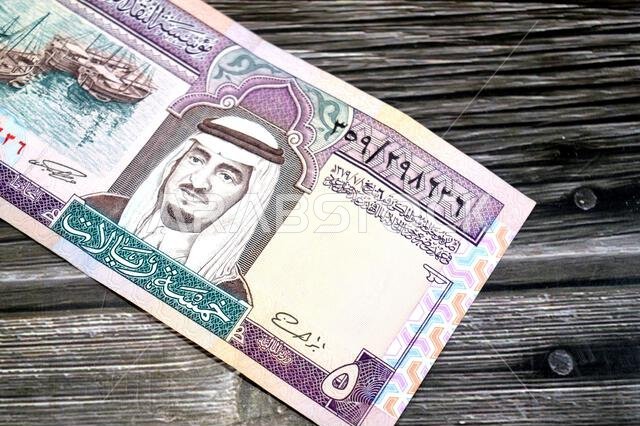 the obverse side of 5 SAR five Saudi Arabian riyals cash money banknote bill, features a portrait of king Fahd Bin AbdulAziz Al Saud and  Dhows at lef