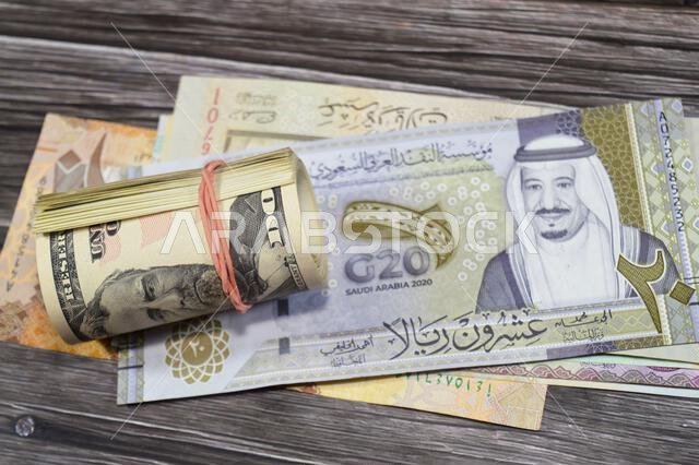صورة لعملة سعودية (ريال سعودي) وخمسين دولارًا أمريكيًا (50 دولارًا أمريكيًا) ملفوفة بشريط مطاطي، تُظهر يوليسيس إس. غرانت، أ.
