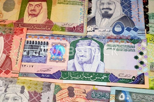 أوراق نقدية من الريال السعودي (SAR) من مختلف العصور والقيم، بدءًا من العملات القديمة ذات الطابع الكلاسيكي في عهد الملك فهد وحتى عهد الملك سلمان.